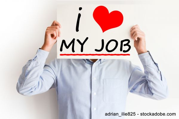 Mann hält Schild hohe mit Aufschrift "I love my job"