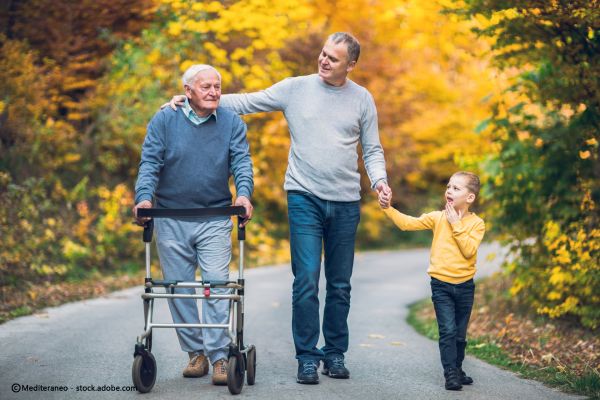 Mann mit Sohn und älterem Mann mit Gehwagen gehen spazieren